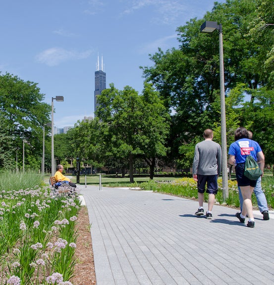 students walking toward the Sears (Willis) Tower on a campus path