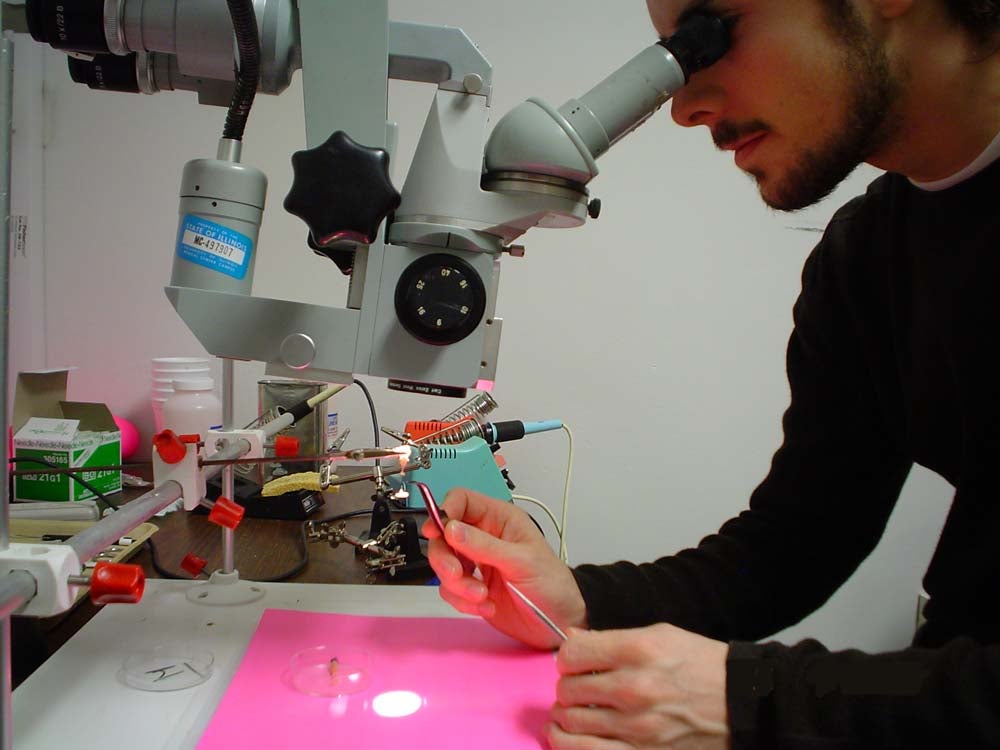 student examining something under microscope