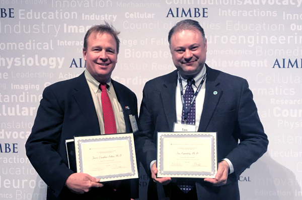 two men holding certificates