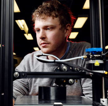 University of Illinois Chicago College of Engineering BME undergraduate Kyle Kinnerk monitors a corrosion cell being made on an FDM 3D printer in the lab.
                  