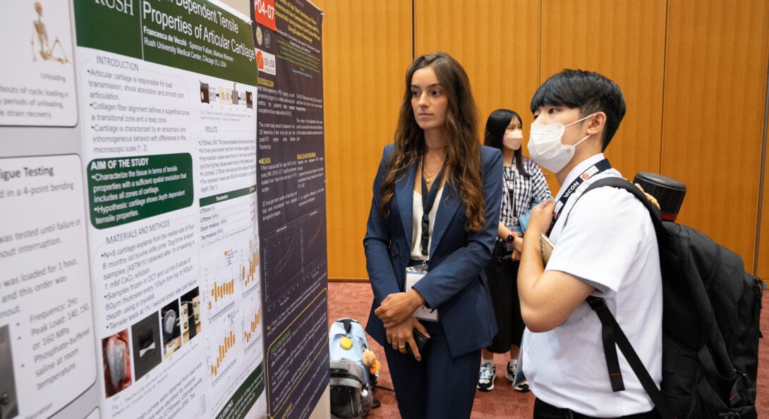 De Vecchi presents her research to a peer attending the International Society of Biomechanics conference