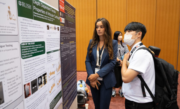 De Vecchi presents her research to a peer attending the International Society of Biomechanics conference