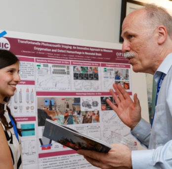 Juliana Benavides Lara presents research to Richard and Loan Hill Department of Biomedical Engineering Department Head and Professor Tom Royston at the Rising BME Scholars Conference. 