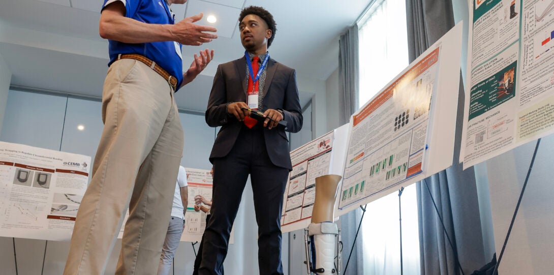 Perri “PJ” Johnson of the University of Tennessee Health Science Center and the University of Memphis (right) presents his research at the conference.